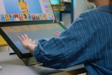 Close up of photographer hands using touch screen monitor