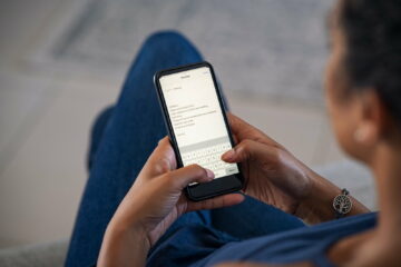 Woman typing email on smartphone