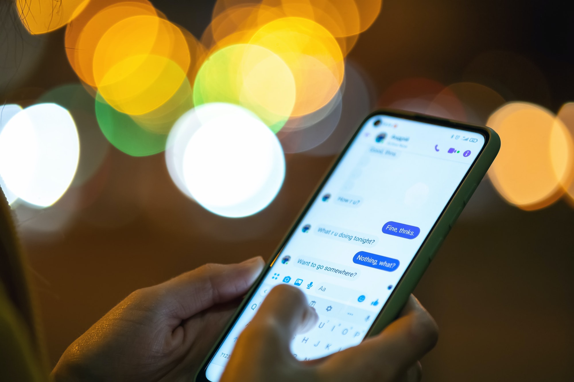 Close up of female hands holding mobile phone exchanging text messages