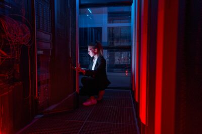 Female system manager configuring servers in server room