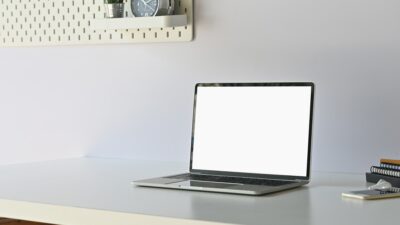 Mockup laptop computer on working table with empty screen display.