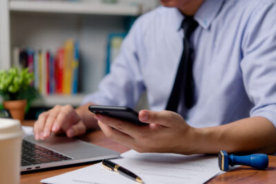 Businessman working on laptop and smartphone. Digital communication internet online.